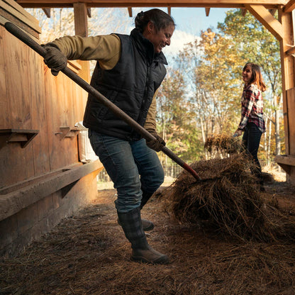 Two people working with hay in a rustic outdoor setting wearing Women's Hale Tall in Black Grey Plaid