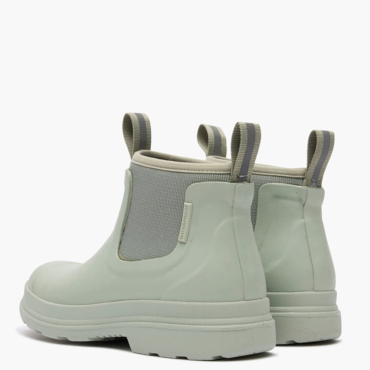 Pair of light green rubber boots with elastic sides on a white background