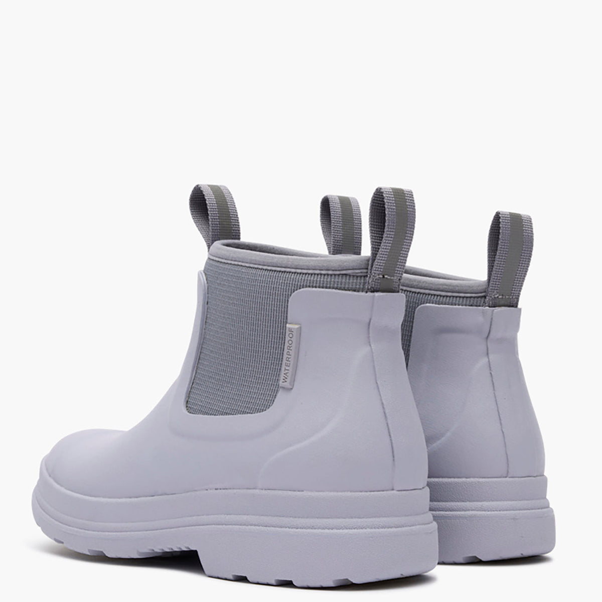 Pair of light gray rain boots with elastic sides on a white background